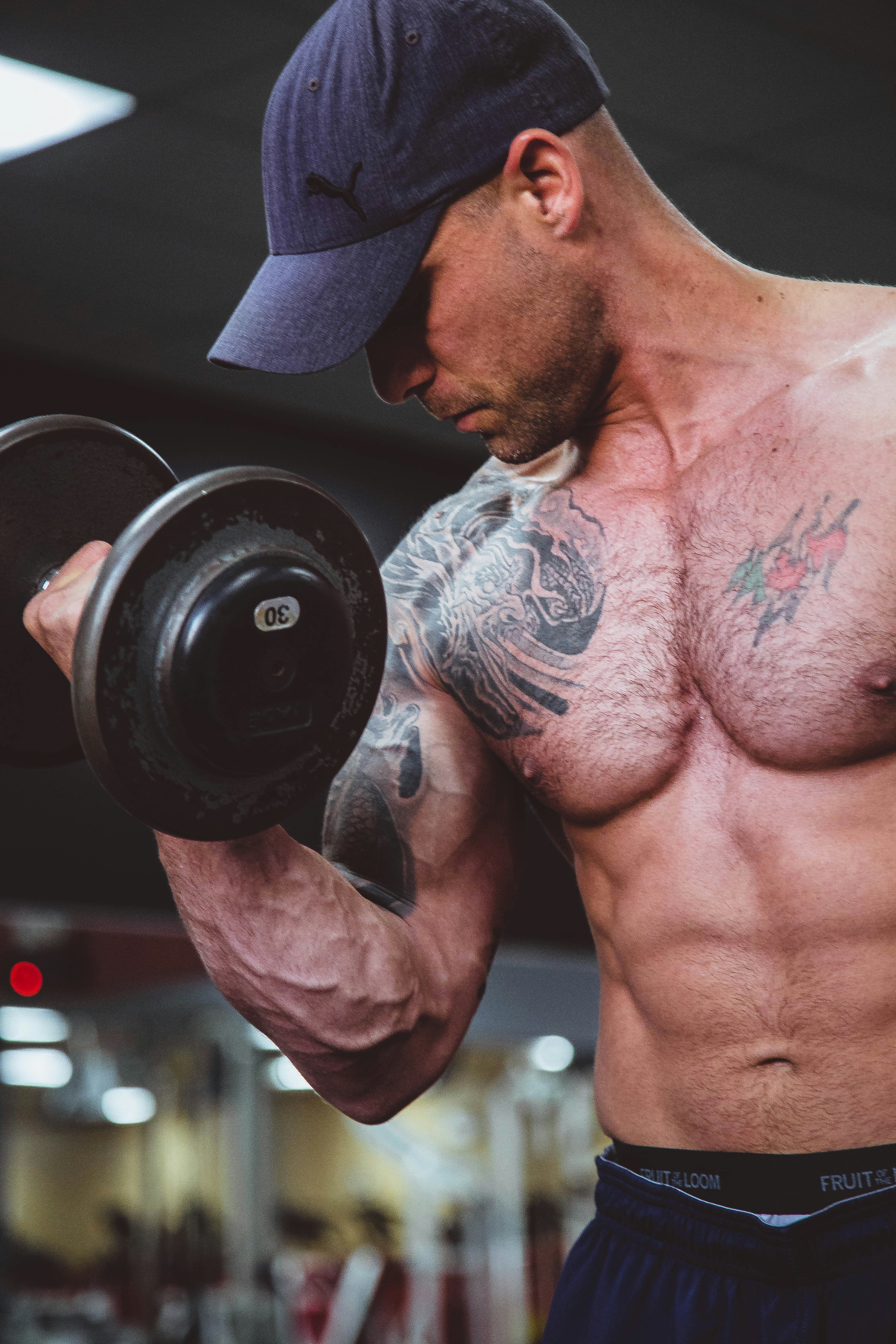 Topless man holding a dumbbell in his right hand