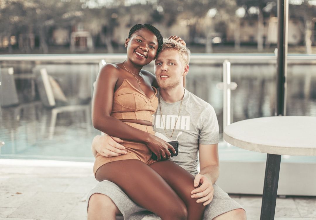 intimate portrait of two people, a man and a woman, embracing and sitting on chair outside